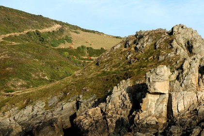Cette baie bien abritée est une plage de galets et de sable fin, et tire son nom des moulins qui existaient autrefois dans la vallée qui la surplombe (écailler le grain). Les roches de l'anse de Cul Rond figurent parmi les plus anciennes de France : plus de 2 milliards d'années.