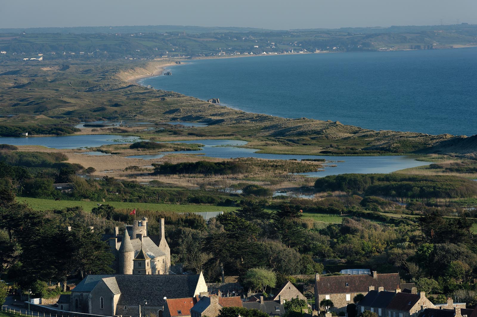 Le village de Vauville fait partie des sites classés de la Hague, Cap Cotentin. Les Pierres Pouquelées, galerie néolithique, sont un témoignage de l'Antiquité.La mare de Vauville est une réserve naturelle. Créée en 1976 c'est l'une des 135 réserves naturelles de France. Géré par le Groupe Ornithologique Normand depuis 1983, c'est un marais d'eau douce protégé de la mer par un étroit cordon dunaire. La mare de Vauville fait 62 ha, il y a plus de 150 espèces d'oiseaux ainsi que de 350 plantes et 16 espèces de batraciens.Un édifice autrefois religieux domine le village. C'est le prieuré de Vauville construit dans les landes, sur le haut d'une colline.Créé par Eric et Nicole Pellerin en 1947, l'exceptionnel jardin botanique du château de Vauville occupe plus de 40 000 m2. Abritant plus de 1000 espèces de l'hémisphère austral, le jardin entoure le château de Vauville dans une ambiance subtropicale tout à fait surprenante.