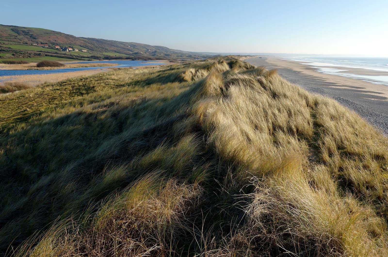 Le village de Vauville fait partie des sites classés de la Hague, Cap Cotentin. Les Pierres Pouquelées, galerie néolithique, sont un témoignage de l'Antiquité.La mare de Vauville est une réserve naturelle. Créée en 1976 c'est l'une des 135 réserves naturelles de France. Géré par le Groupe Ornithologique Normand depuis 1983, c'est un marais d'eau douce protégé de la mer par un étroit cordon dunaire. La mare de Vauville fait 62 ha, il y a plus de 150 espèces d'oiseaux ainsi que de 350 plantes et 16 espèces de batraciens.Un édifice autrefois religieux domine le village. C'est le prieuré de Vauville construit dans les landes, sur le haut d'une colline.Créé par Eric et Nicole Pellerin en 1947, l'exceptionnel jardin botanique du château de Vauville occupe plus de 40 000 m2. Abritant plus de 1000 espèces de l'hémisphère austral, le jardin entoure le château de Vauville dans une ambiance subtropicale tout à fait surprenante.
