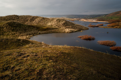 Le village de Vauville fait partie des sites classés de la Hague, Cap Cotentin. Les Pierres Pouquelées, galerie néolithique, sont un témoignage de l'Antiquité.La mare de Vauville est une réserve naturelle. Créée en 1976 c'est l'une des 135 réserves naturelles de France. Géré par le Groupe Ornithologique Normand depuis 1983, c'est un marais d'eau douce protégé de la mer par un étroit cordon dunaire. La mare de Vauville fait 62 ha, il y a plus de 150 espèces d'oiseaux ainsi que de 350 plantes et 16 espèces de batraciens.Un édifice autrefois religieux domine le village. C'est le prieuré de Vauville construit dans les landes, sur le haut d'une colline.Créé par Eric et Nicole Pellerin en 1947, l'exceptionnel jardin botanique du château de Vauville occupe plus de 40 000 m2. Abritant plus de 1000 espèces de l'hémisphère austral, le jardin entoure le château de Vauville dans une ambiance subtropicale tout à fait surprenante.