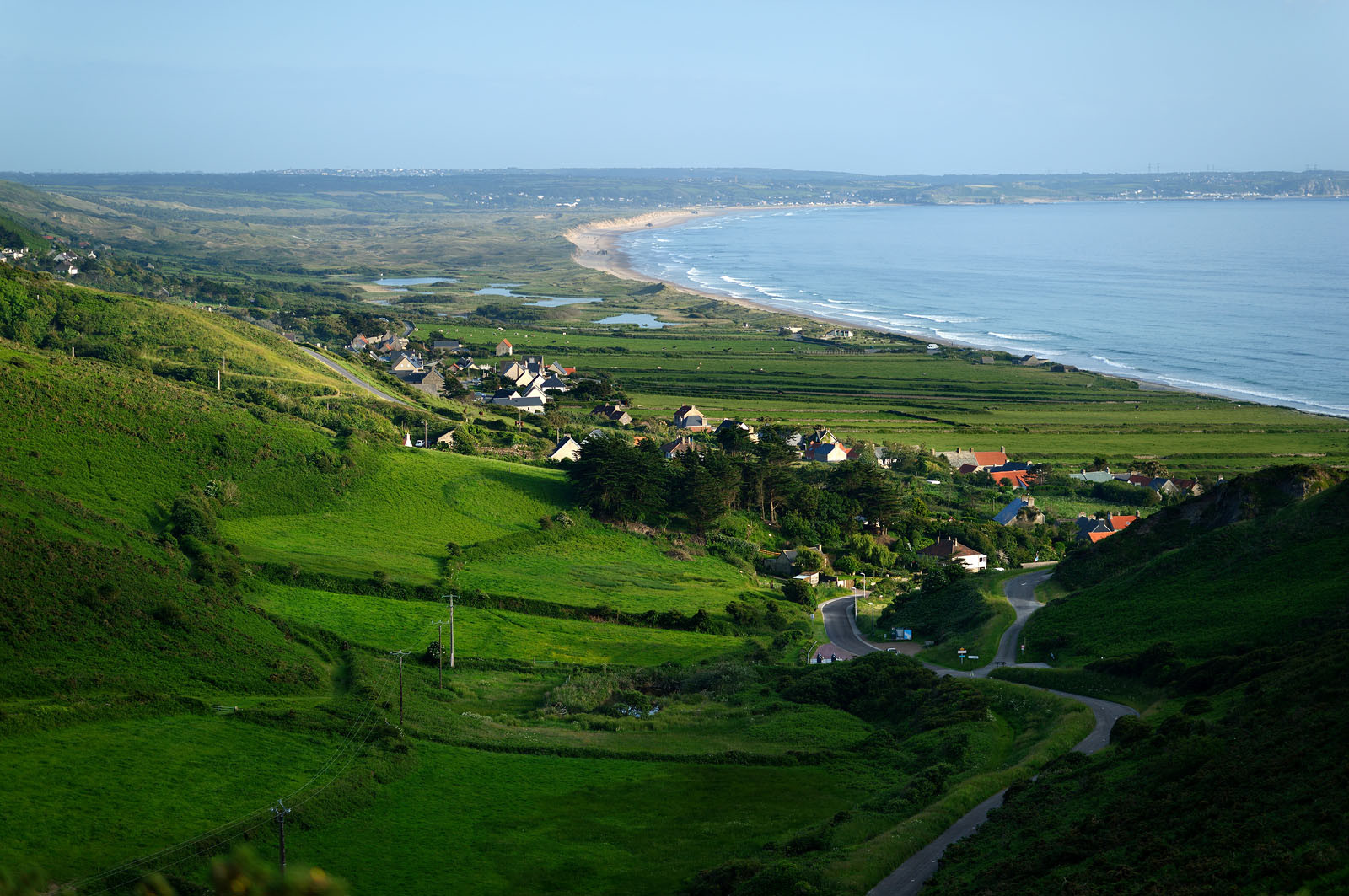 Le village de Vauville fait partie des sites classés de la Hague, Cap Cotentin. Les Pierres Pouquelées, galerie néolithique, sont un témoignage de l'Antiquité.La mare de Vauville est une réserve naturelle. Créée en 1976 c'est l'une des 135 réserves naturelles de France. Géré par le Groupe Ornithologique Normand depuis 1983, c'est un marais d'eau douce protégé de la mer par un étroit cordon dunaire. La mare de Vauville fait 62 ha, il y a plus de 150 espèces d'oiseaux ainsi que de 350 plantes et 16 espèces de batraciens.Un édifice autrefois religieux domine le village. C'est le prieuré de Vauville construit dans les landes, sur le haut d'une colline.Créé par Eric et Nicole Pellerin en 1947, l'exceptionnel jardin botanique du château de Vauville occupe plus de 40 000 m2. Abritant plus de 1000 espèces de l'hémisphère austral, le jardin entoure le château de Vauville dans une ambiance subtropicale tout à fait surprenante.