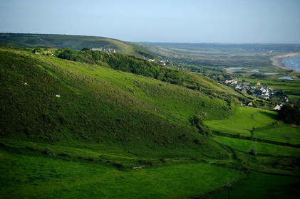 Le village de Vauville fait partie des sites classés de la Hague, Cap Cotentin. Les Pierres Pouquelées, galerie néolithique, sont un témoignage de l'Antiquité.La mare de Vauville est une réserve naturelle. Créée en 1976 c'est l'une des 135 réserves naturelles de France. Géré par le Groupe Ornithologique Normand depuis 1983, c'est un marais d'eau douce protégé de la mer par un étroit cordon dunaire. La mare de Vauville fait 62 ha, il y a plus de 150 espèces d'oiseaux ainsi que de 350 plantes et 16 espèces de batraciens.Un édifice autrefois religieux domine le village. C'est le prieuré de Vauville construit dans les landes, sur le haut d'une colline.Créé par Eric et Nicole Pellerin en 1947, l'exceptionnel jardin botanique du château de Vauville occupe plus de 40 000 m2. Abritant plus de 1000 espèces de l'hémisphère austral, le jardin entoure le château de Vauville dans une ambiance subtropicale tout à fait surprenante.