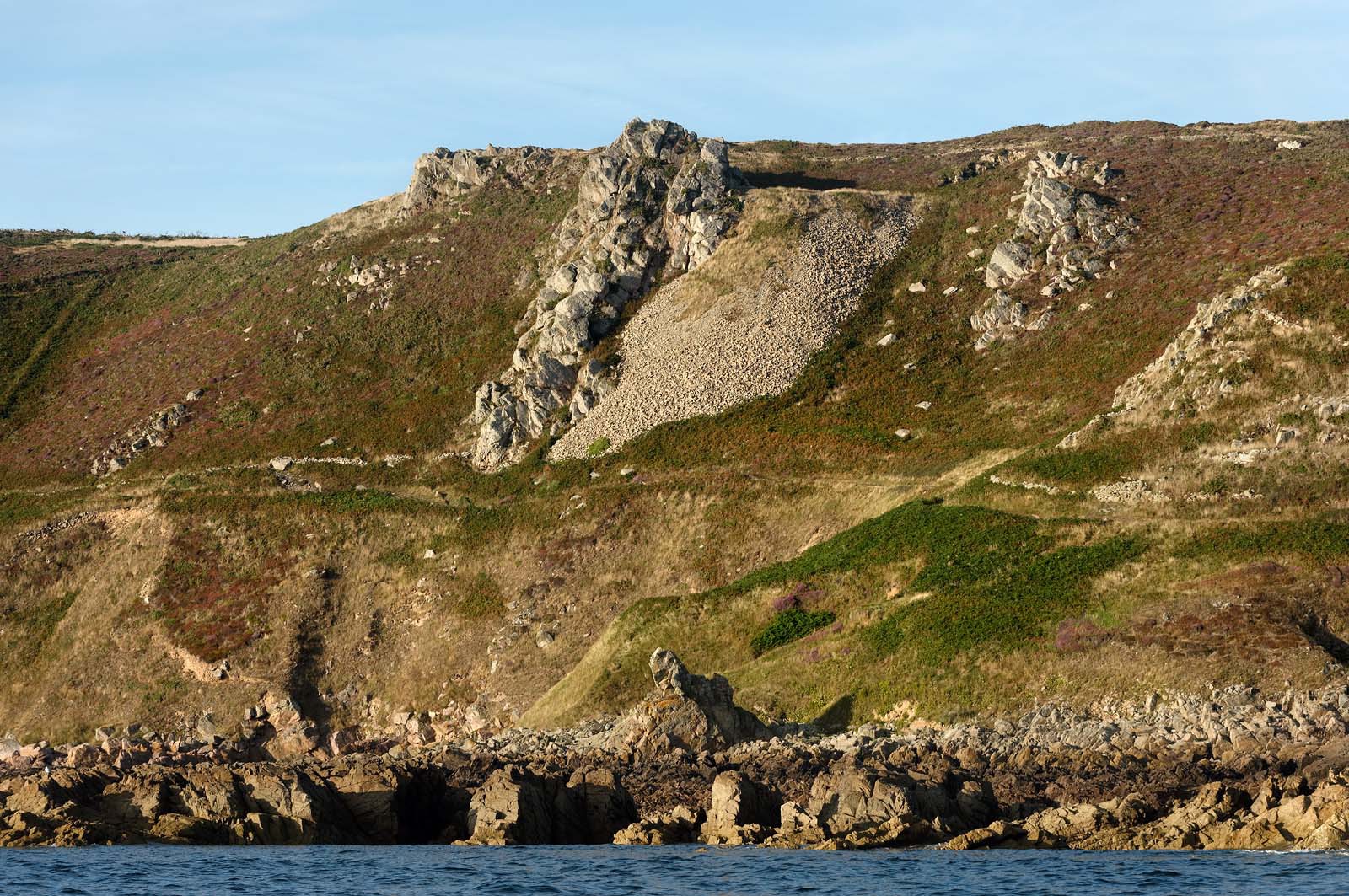Cette baie bien abritée est une plage de galets et de sable fin, et tire son nom des moulins qui existaient autrefois dans la vallée qui la surplombe (écailler le grain). Les roches de l'anse de Cul Rond figurent parmi les plus anciennes de France : plus de 2 milliards d'années.