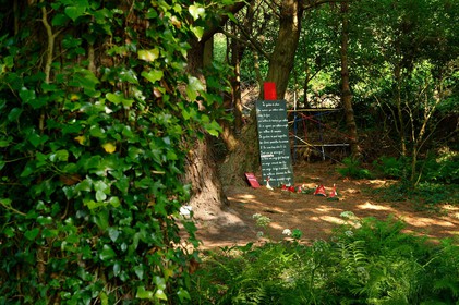 En hommage au poète, ses amis dont Gérard Fusberti, propriétaire du terrain et gardien du temple, décident de créer un jardin où chacun plantera son arbre ou laissera une de ses créations. Montand, Reggiani, Greco ou Mouloudji plantèrent chacun leur double végétal lors de la célébration du dixième anniversaire de la mort de Prévert, un eucalyptus aujourd'hui haut d'au moins 20 mètres pour Mouloudji.Se balader dans ce jardin, c'est pénétrer dans l'univers du poète. Au milieu des arbres d'ornement, des bambous peints de rouge vif, des arbres fruitiers, des camélias, des azalées, des gunneras (que Prévert adorait) et des hortensias, des œuvres d'art se révèlent ça et là, tantôt un portrait, tantôt une sculpture ou une installation. Des arbres peints prennent vie, une main rouge semblant sortir de leur entrailles, le ruisseau qui coule en cascade murmure une douce poésie, que l'on retrouve en quelques phrases inscrites sur des plaques qui surgissent au milieu de cette jungle organisée. (Saint-Germain-des-Vaux Manche)